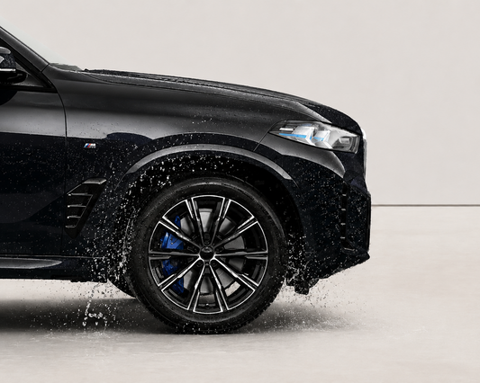 Black car with wet tires on a gray background. With wheel ceramic coating by element care melbourne