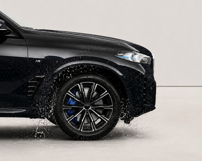 Black car with wet tires on a gray background. With wheel ceramic coating by element care melbourne